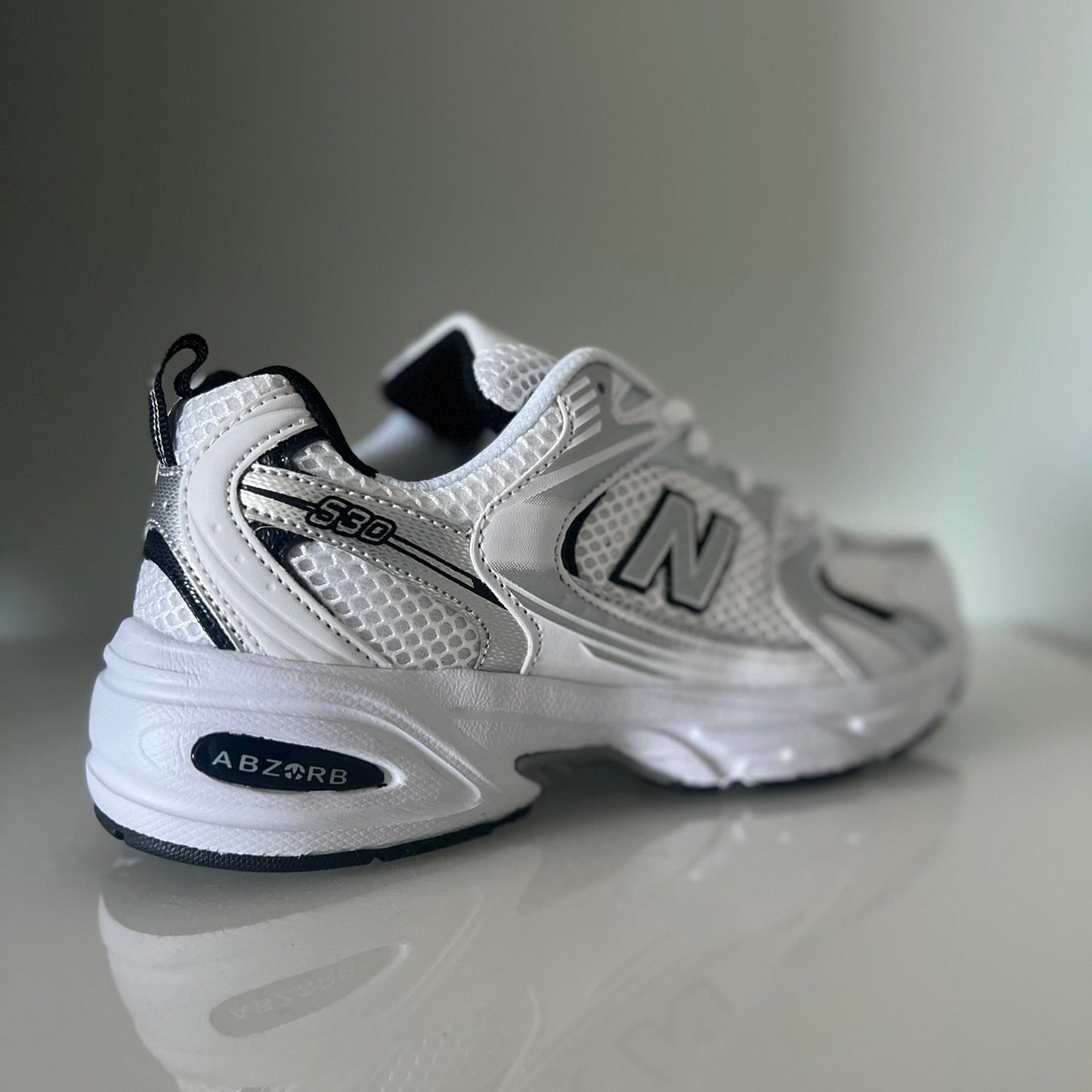 Zapatillas premium modelo 530 blanca con detalles gris y negros