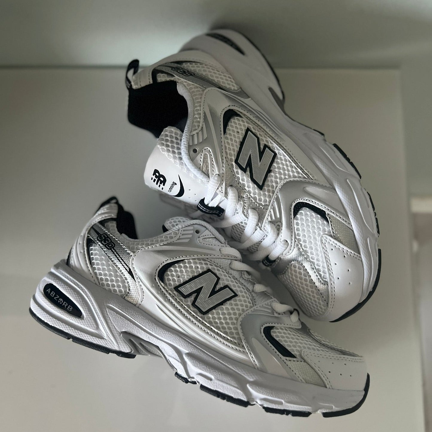 Zapatillas premium modelo 530 blanca con detalles gris y negros